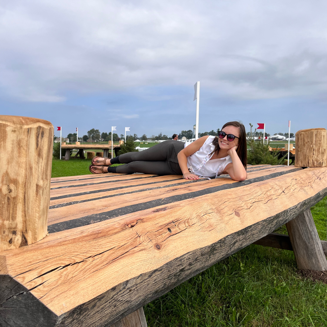StableFeed employee Olivia laying on a cross country jump.