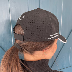Backside of our black StableFeed cap with our logo over the back and What You Feed Your Horse Matters stitched on the right side. 